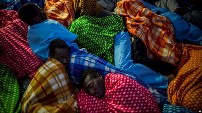 FILE - Refugees and migrants rest aboard the Golfo Azurro, a Spanish rescue ship, after being found off the Libyan coast, early in the morning, Feb. 23, 2017.
